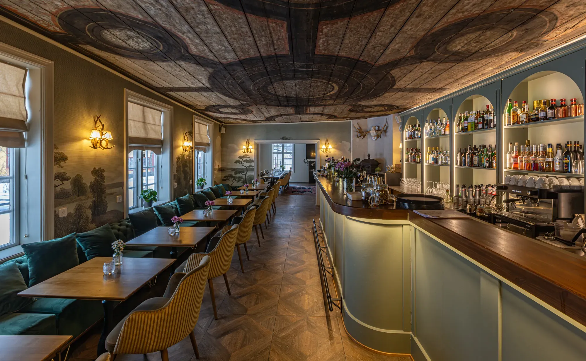 Restaurangens bar och dukade bord under det målade 1690-talstaket.