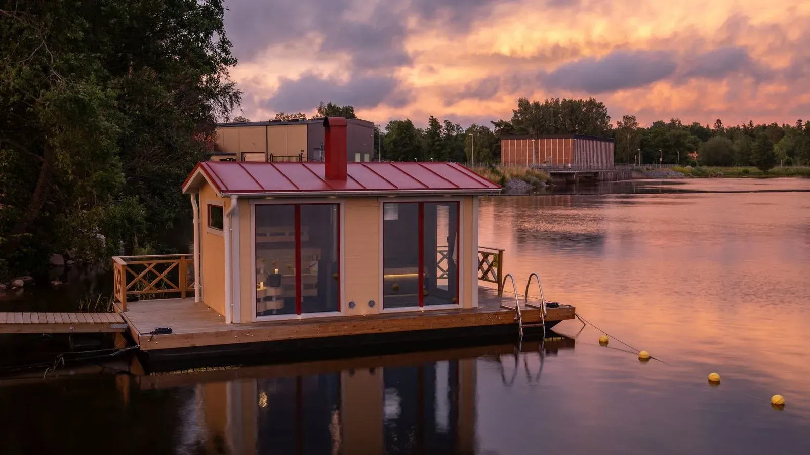 Den vedeldade bastubåten förtöjd vid bryggan på Dalälvens stilla vatten.