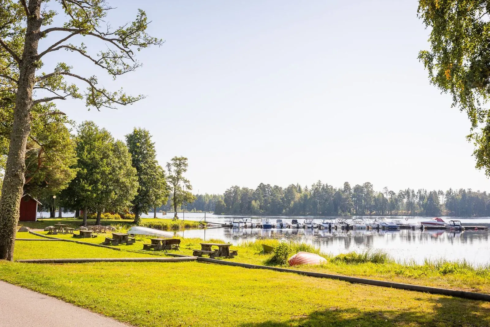 Lugn promenadväg längs Dalälvens vatten med träd och natur runt omkring.