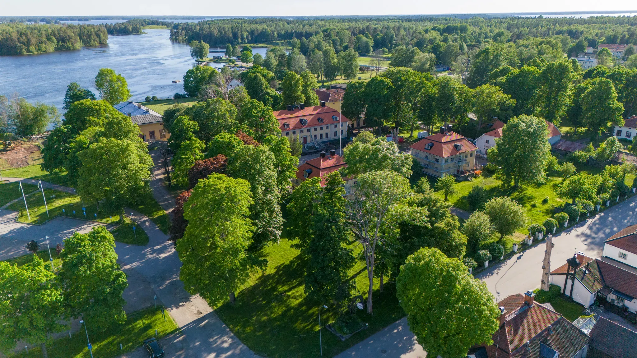 Flygbild över herrgårdsområdet med parken, kyrkan och Dalälven.