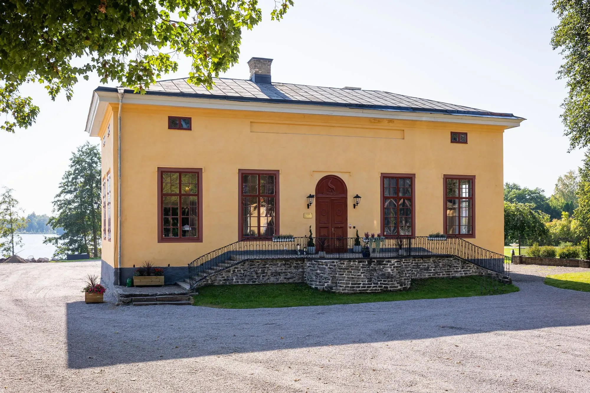 Grillska Husets gula stenfasad och entré sedd från herrgårdens gårdsplan.