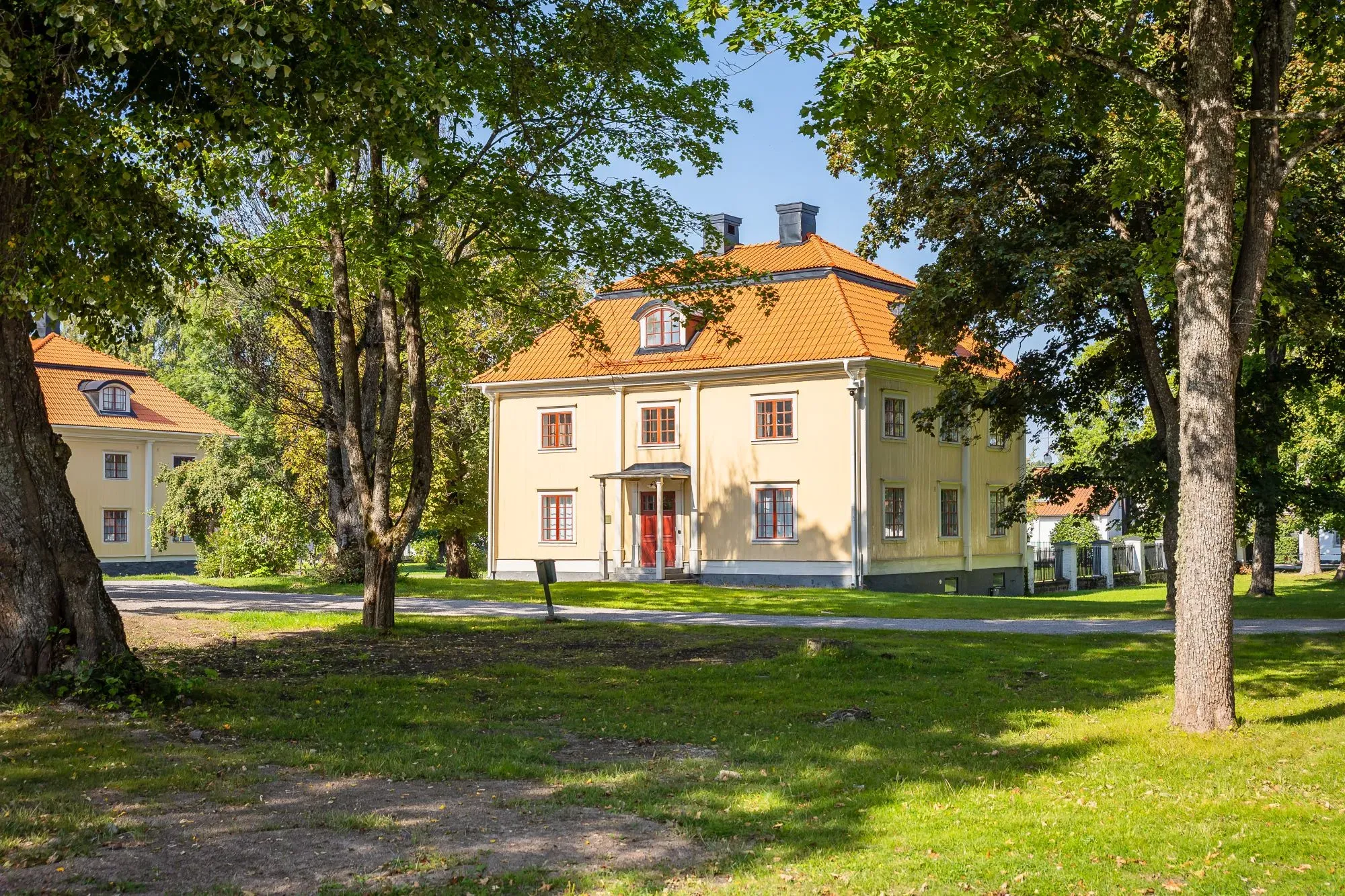 Ankarhusets ljusa fasad med spröjsade fönster vid den historiska gårdsplanen.