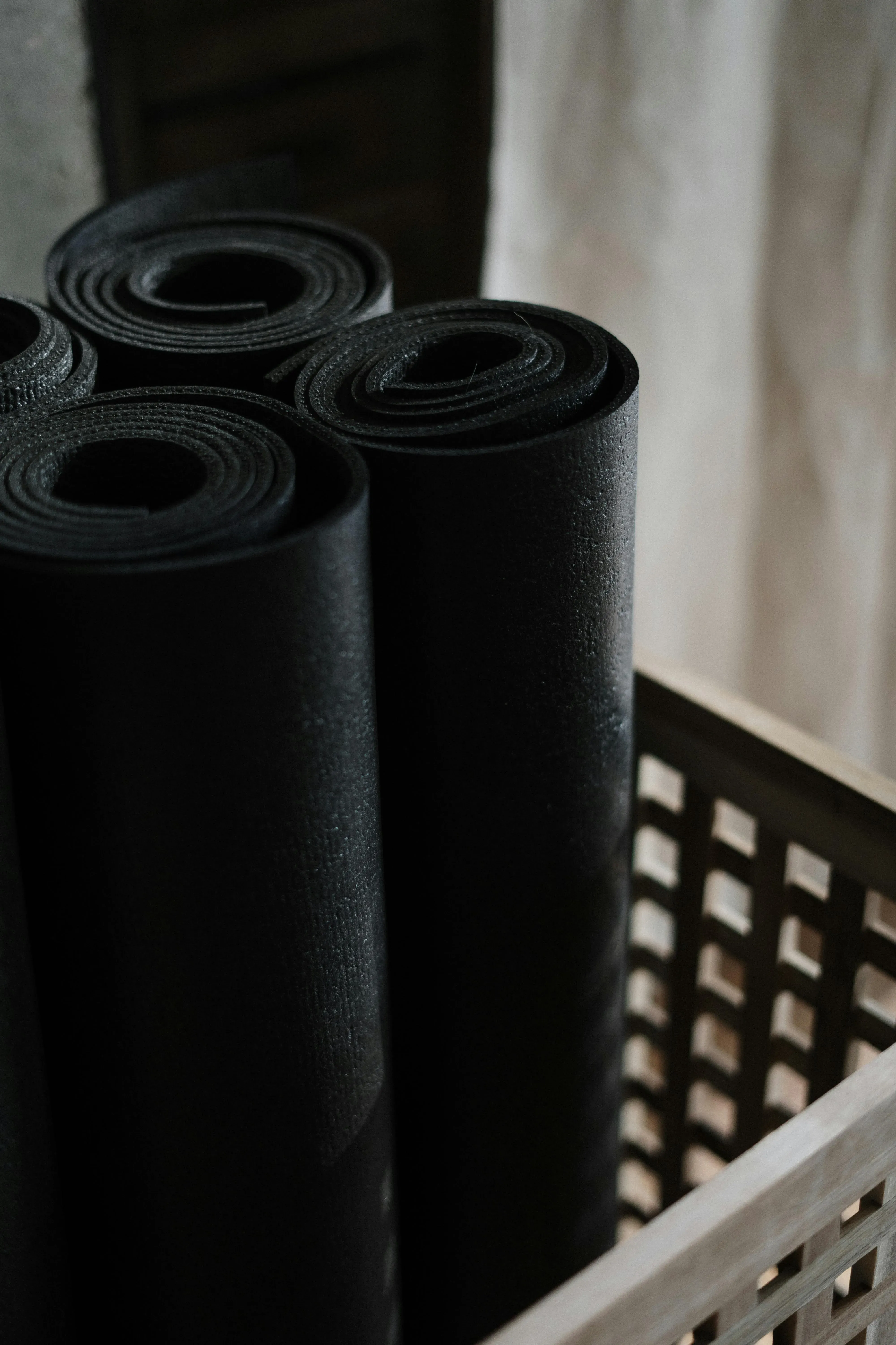 Ihoprullade yogamattor i en trälåda.