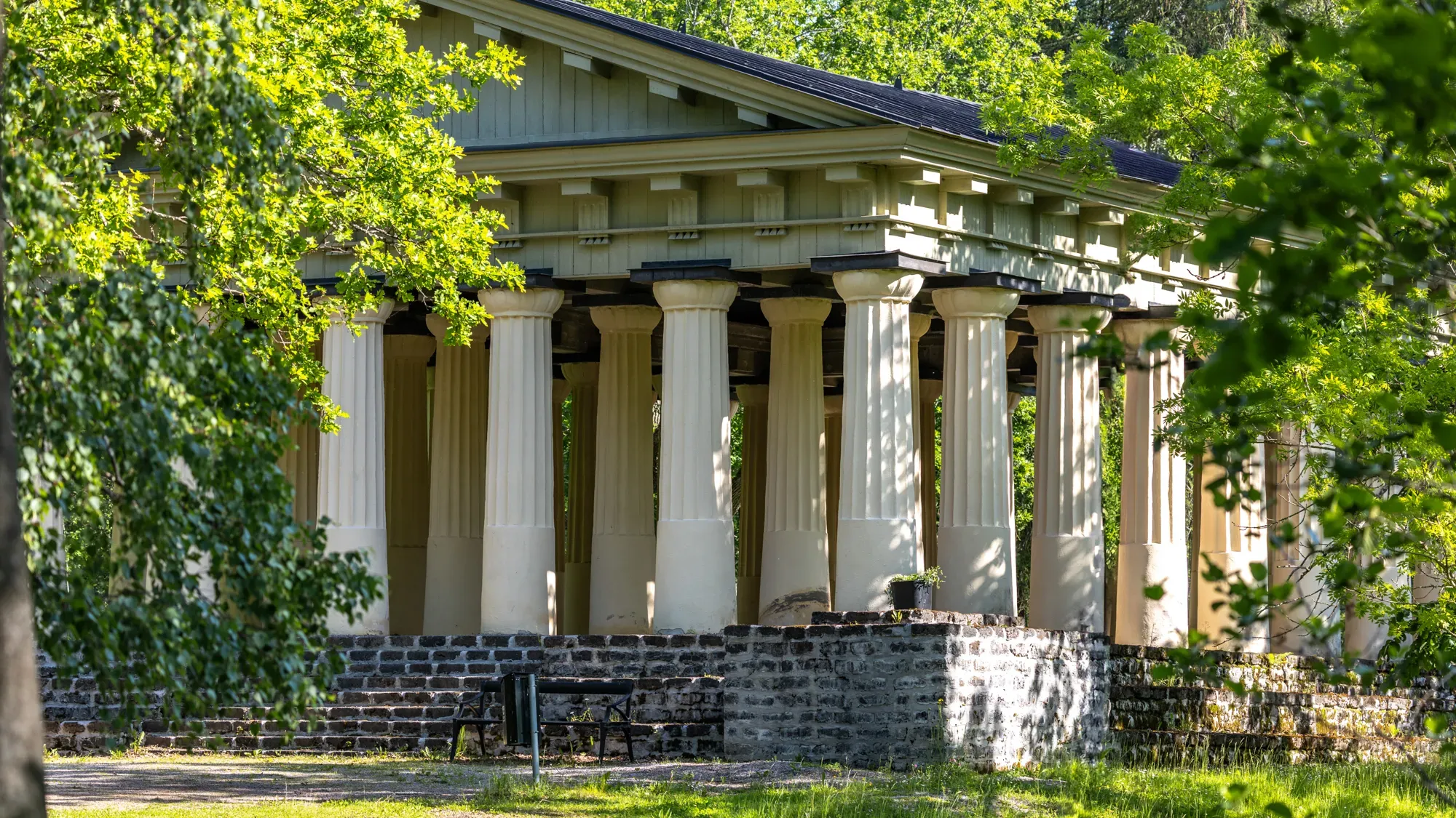 Det grekiska templets vita kolonnrad på sin stengrund.